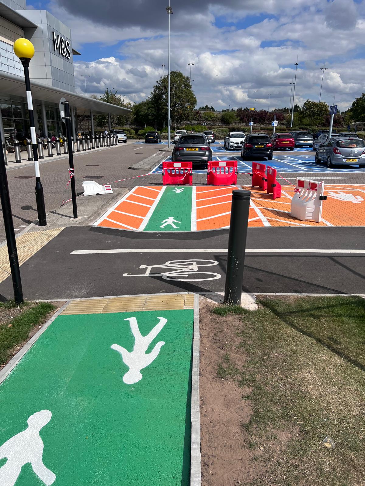 Custom car park markings including disabled bay symbols and directional arrows